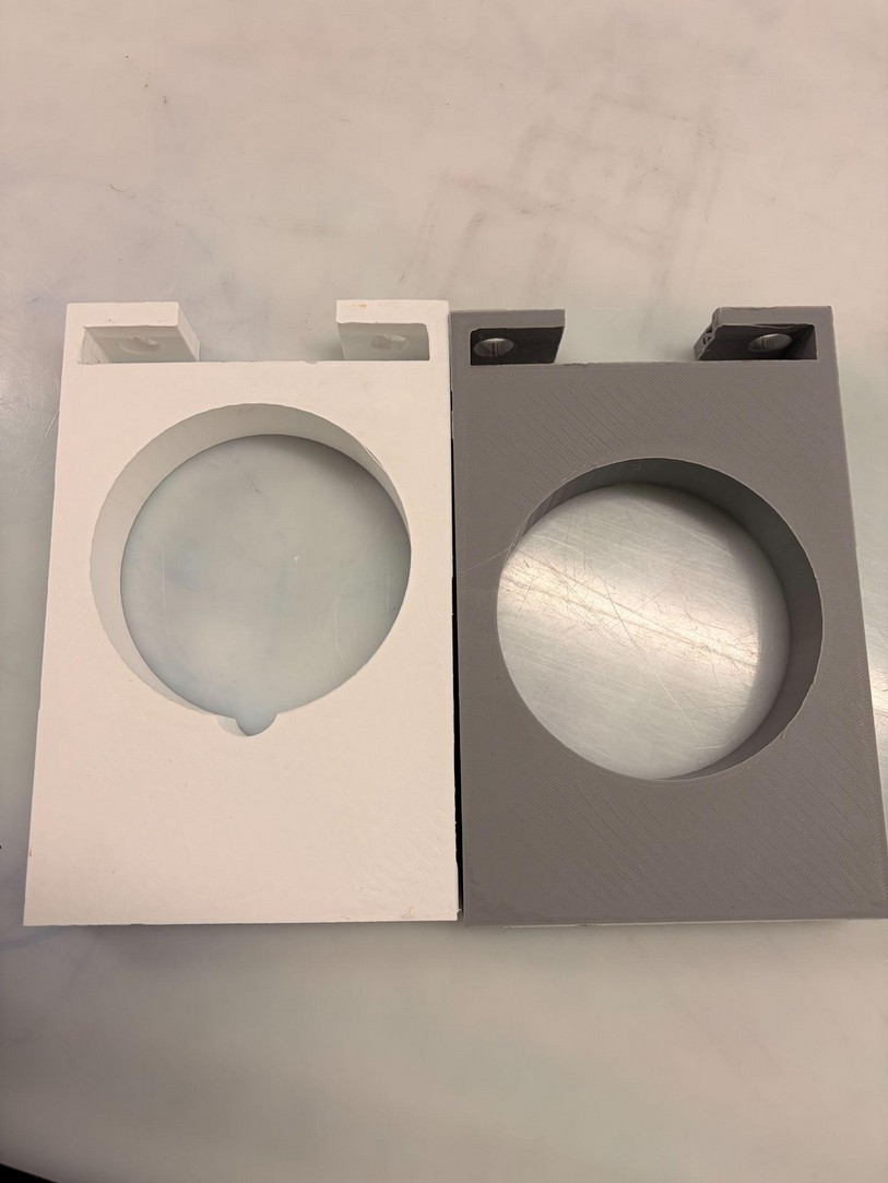 Two 3D-printed electromagnet housing design iterations side by side